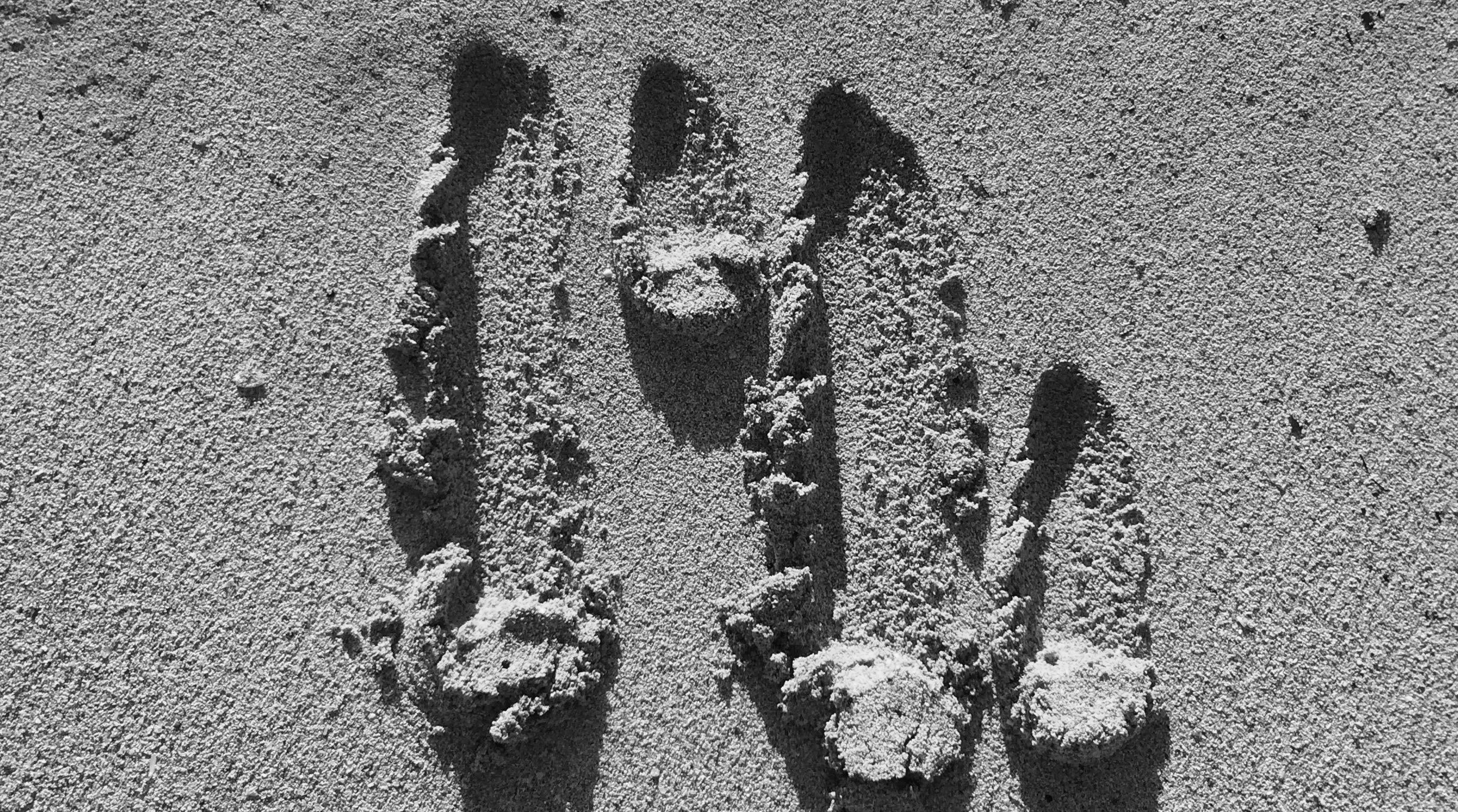 unser re-lounge Logo aus einem abstrakten „r“ und einem abstrakten „l“ in den Sand eines Strandes gezeichnet