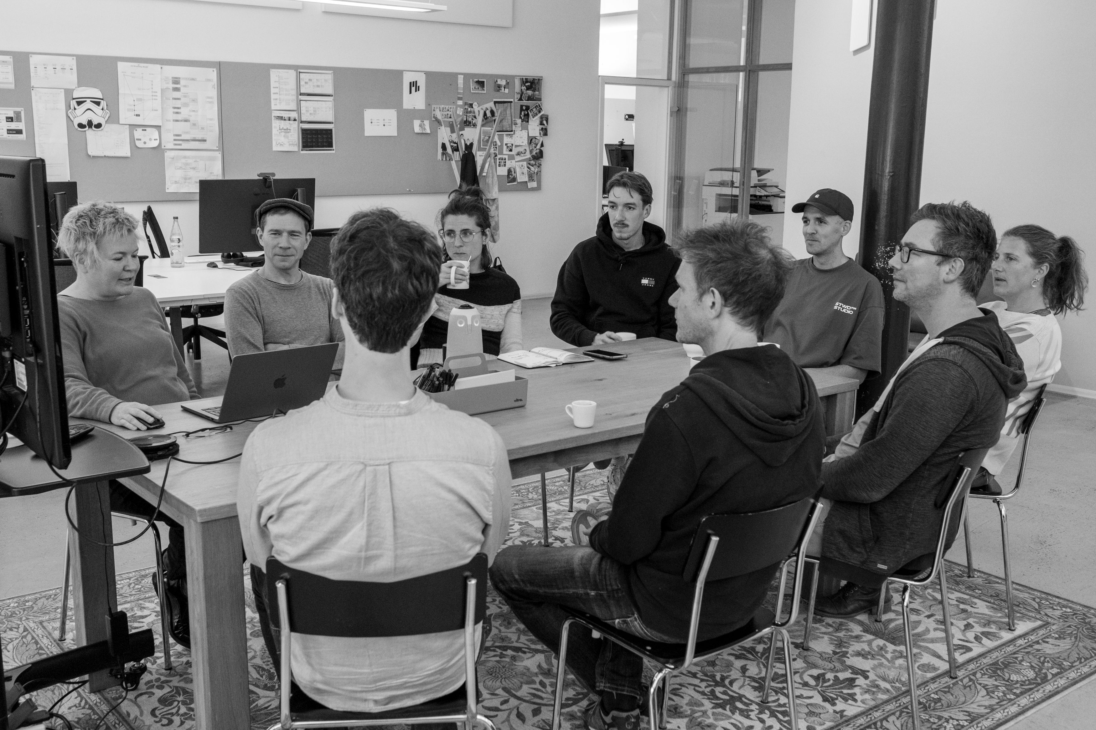 Team sitzt gemeinsam an einem Tisch in einem Workshop