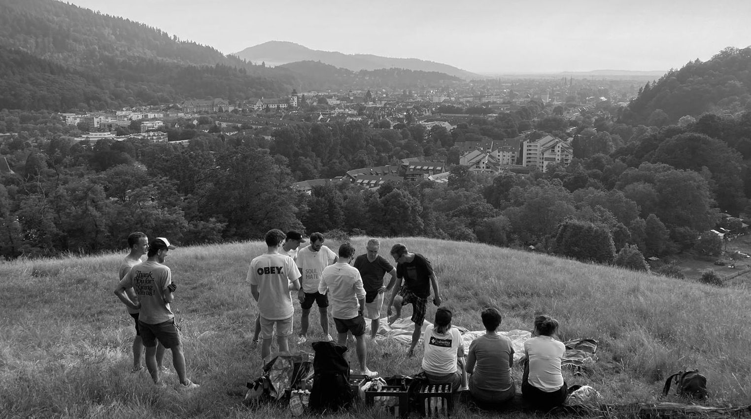 re-lounge Team blickt von einem Hügel in eine Landschaft